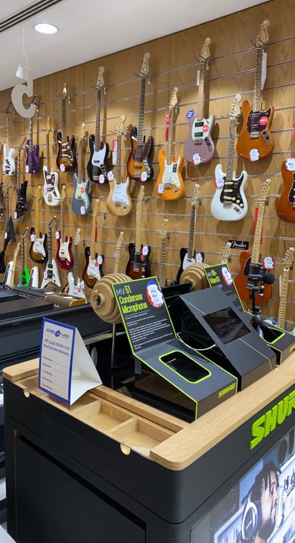 A wide selection of electric guitars and audio equipment displayed in a retail store.
