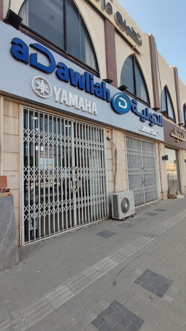 The exterior of aDawliah Electronics, a Yamaha and Bose dealer, with its storefront secured by metal gates.