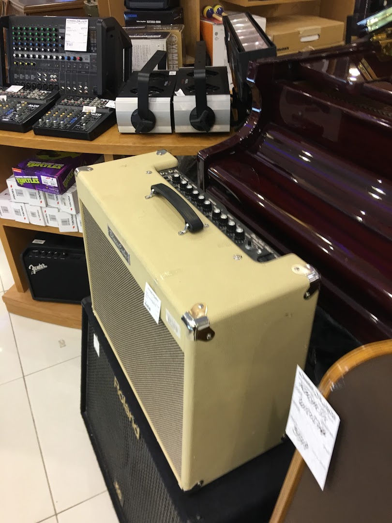 A variety of audio equipment, including amplifiers and mixers, displayed in a retail store.