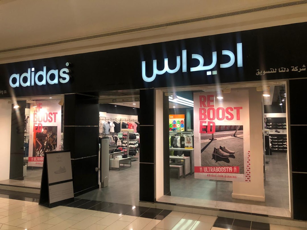The entrance of an Adidas store showcasing sportswear and footwear with prominent branding.