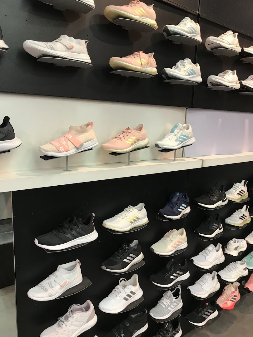 A wall display showcasing a variety of Adidas athletic shoes in different colors and styles.