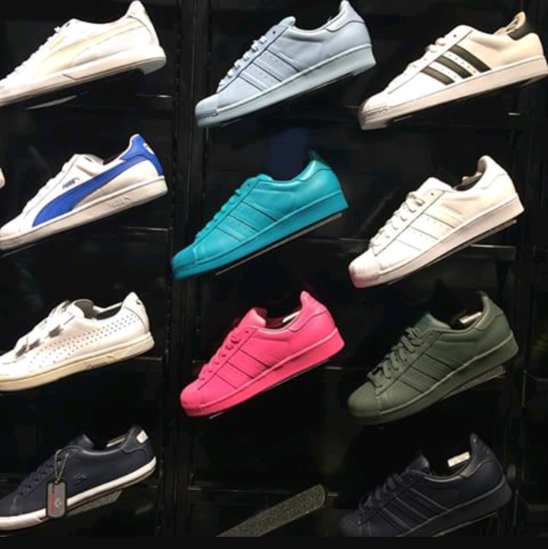 A display of various colorful Adidas sneakers on shelves.