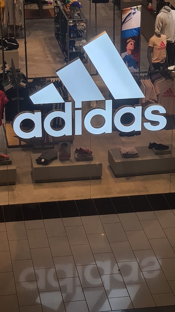 The Adidas store features its iconic logo and displays of athletic footwear and apparel.