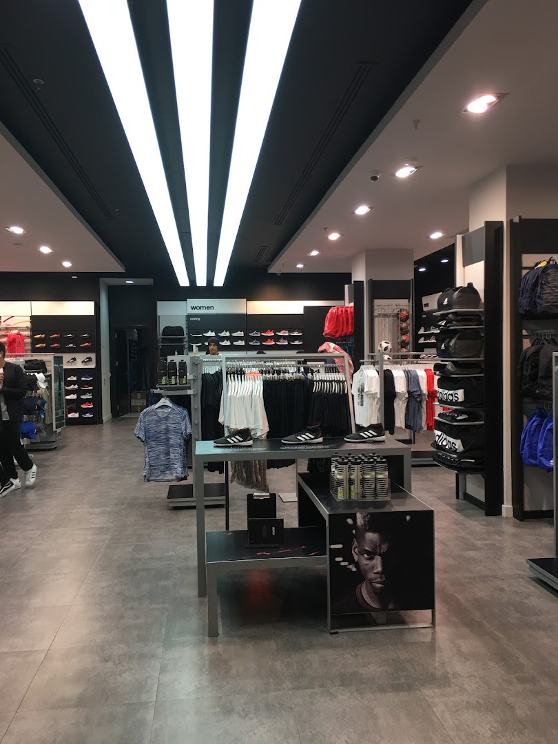 Interior view of an Adidas store showcasing sportswear, shoes, and accessories.