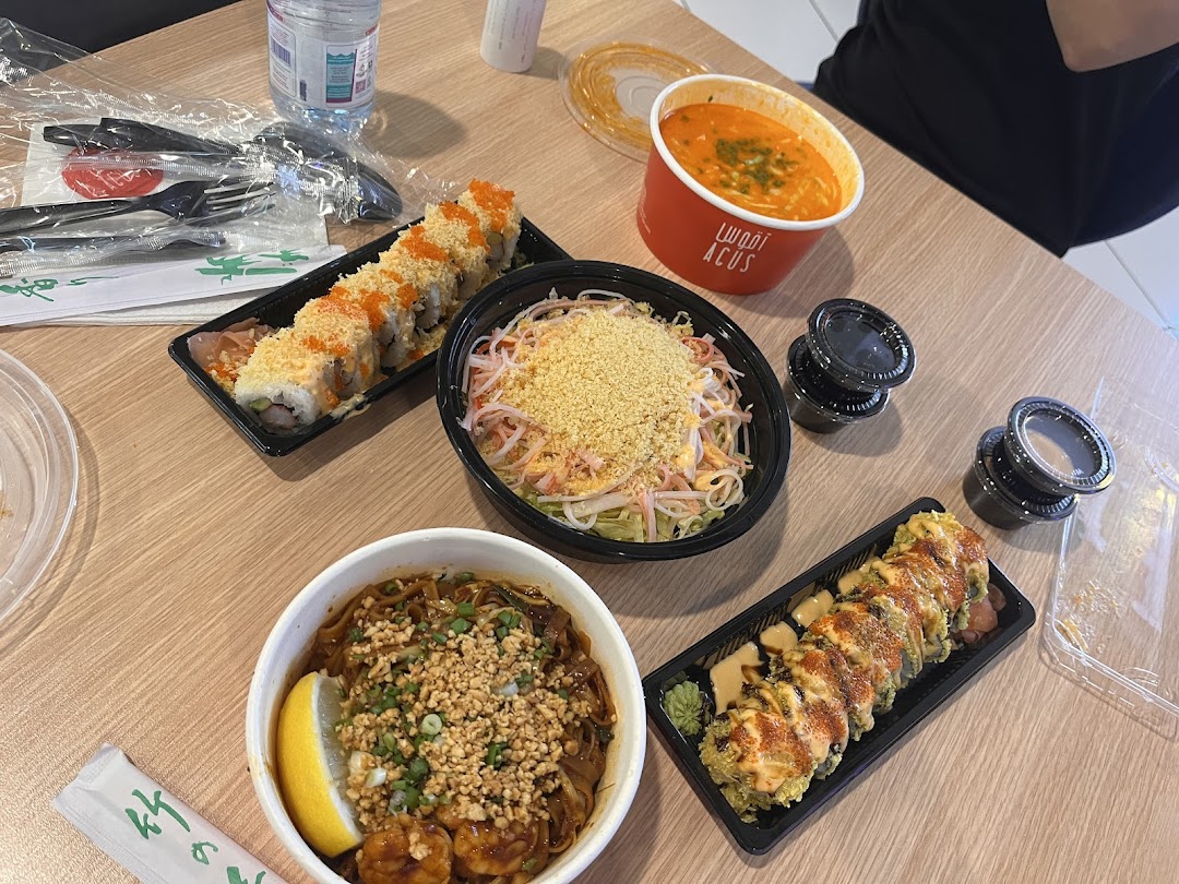 A table laden with various Japanese dishes including sushi rolls, noodle bowls, and soup.