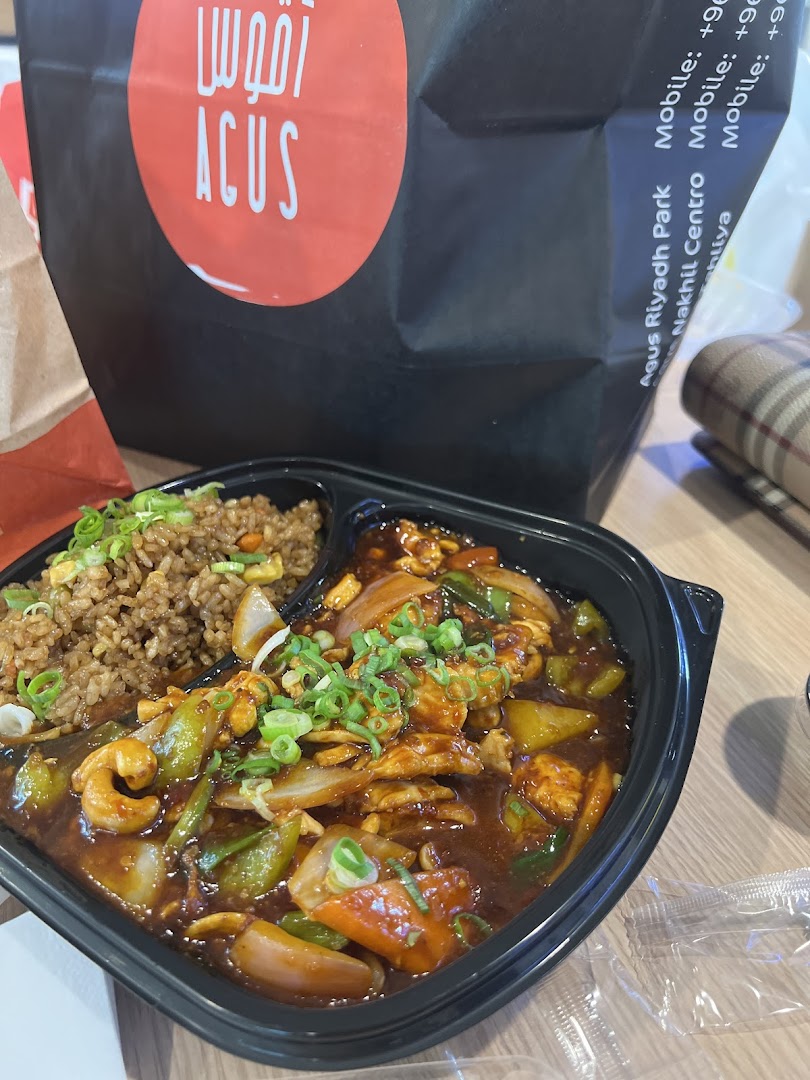 A takeout bag from Agus Restaurant with a meal of fried rice and a stir-fry dish.