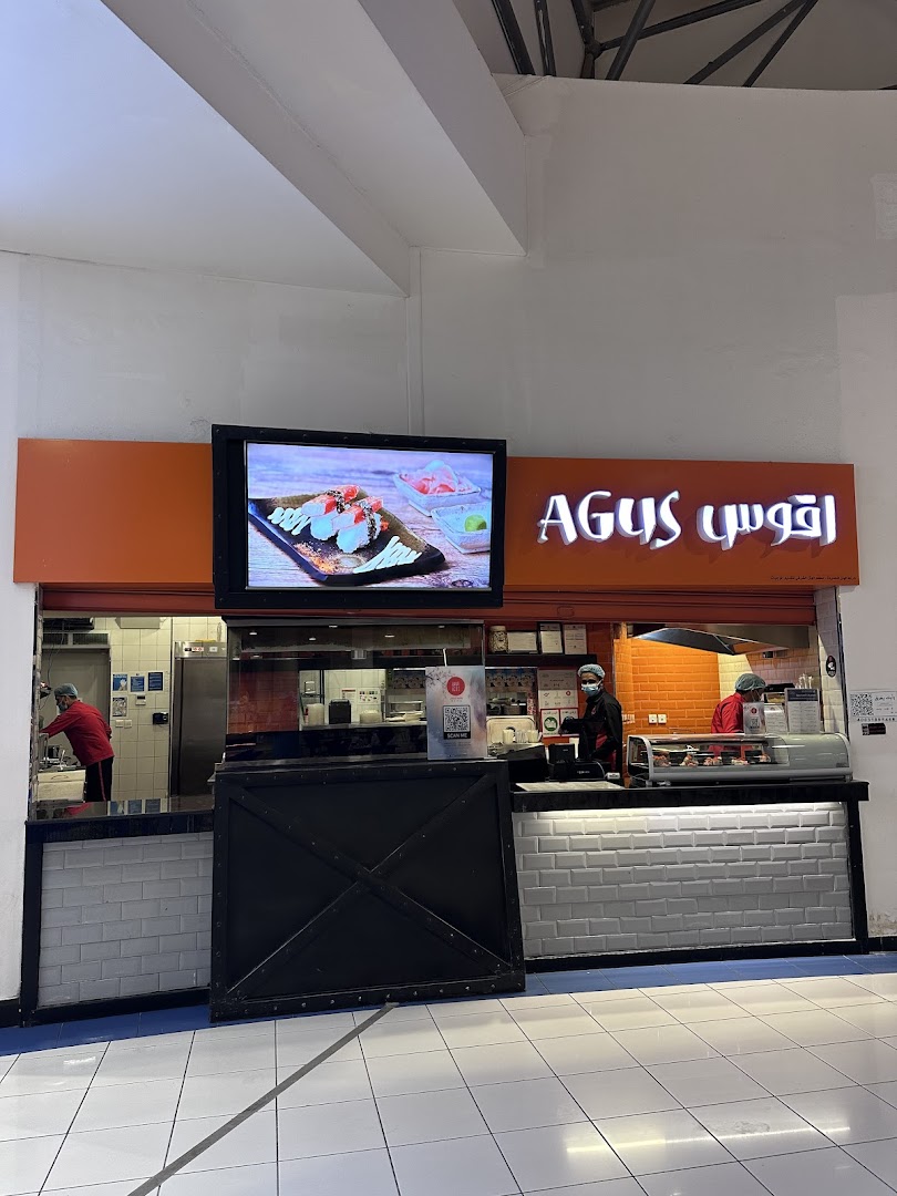 Agus Restaurant's storefront with staff preparing food behind the counter.