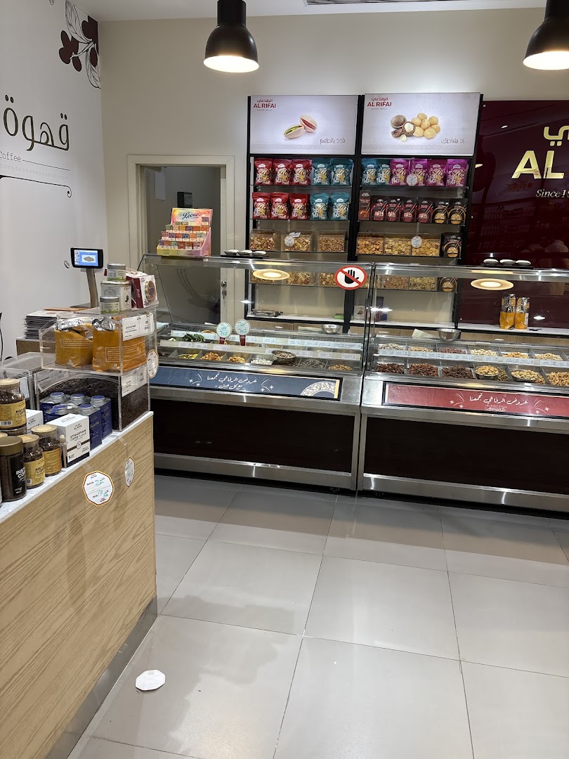 Interior view of Al Rifai Roastery showcasing a variety of nuts, coffee, and sweets in display cases.