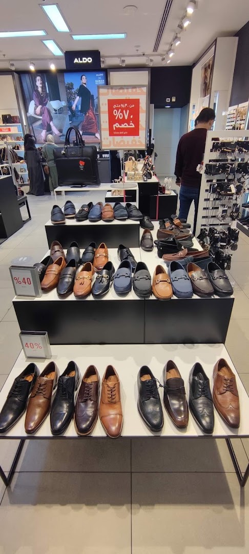 Aldo store interior showcasing a wide selection of men's dress shoes and handbags.