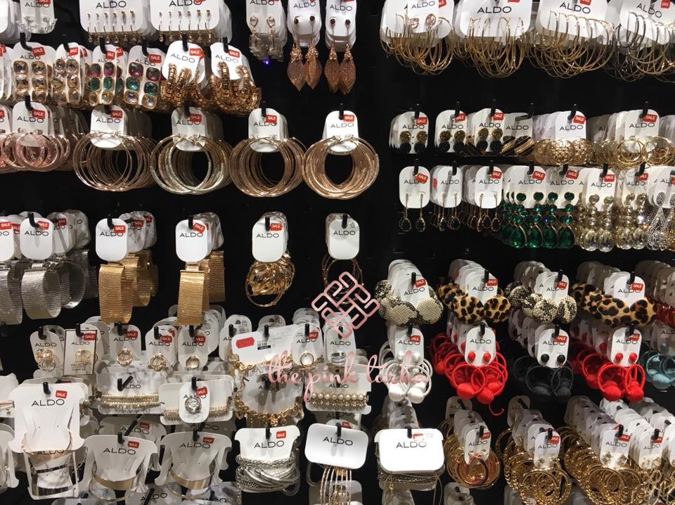 A display of various Aldo accessories including earrings, bracelets, and hair ties.