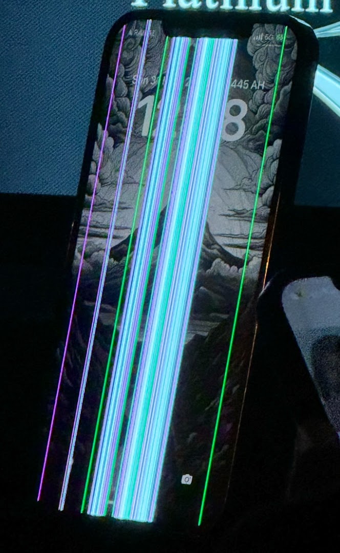A smartphone with a cracked and distorted screen displaying colorful vertical lines.
