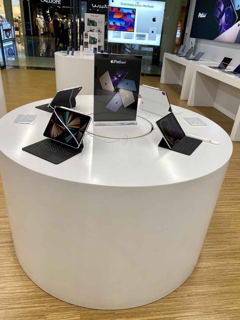 Display of iPads and accessories on a white circular table in a retail store.