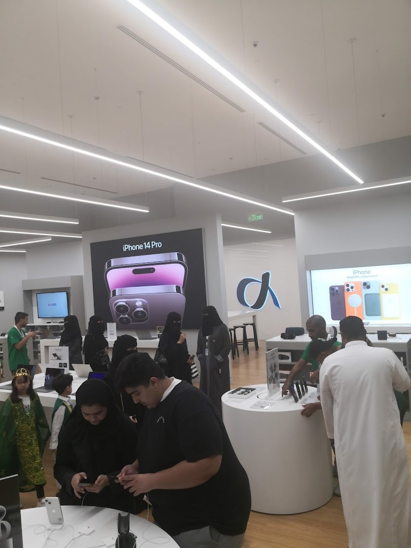 Customers browse Apple products inside a modern, well-lit retail store.
