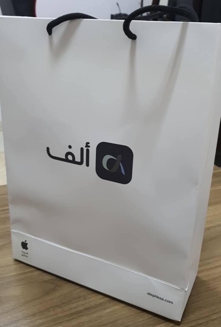 A white shopping bag with the Aleph logo and Apple branding.