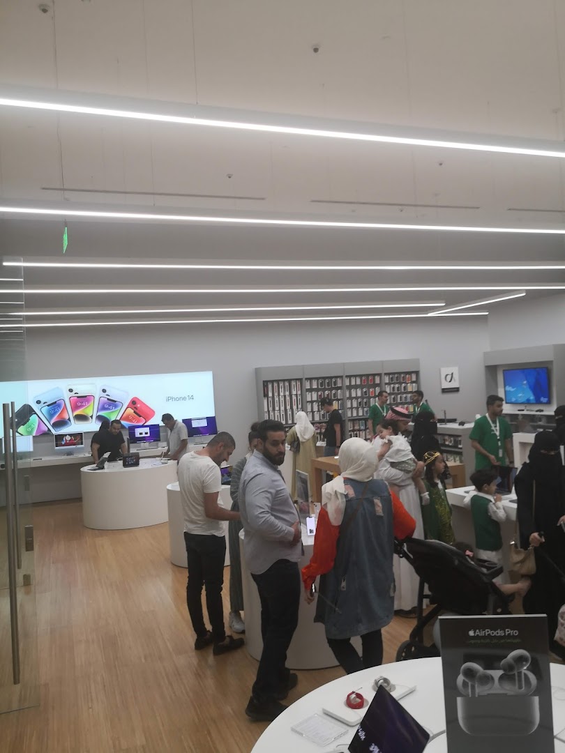 Customers browse Apple products in a modern, well-lit retail store.