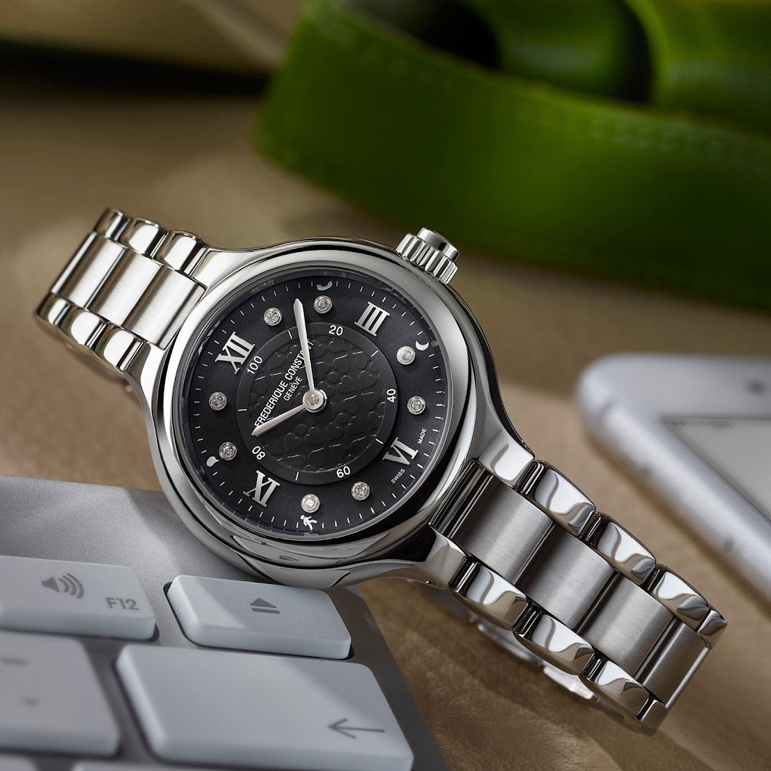 A close-up of a luxury watch with a diamond-studded black dial and a silver band.