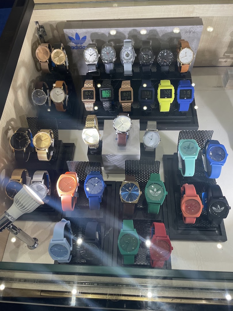 A display case filled with a variety of Adidas watches in different colors and styles.