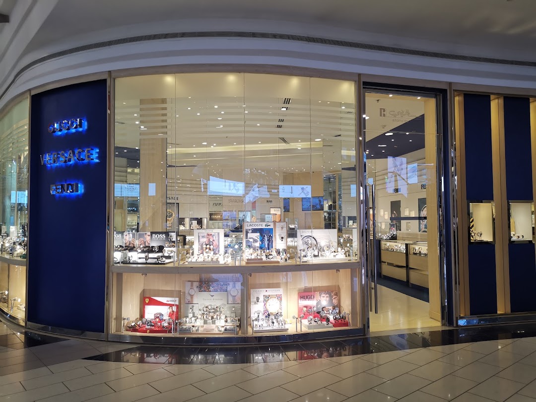 The exterior of Alhomaidhi Watches, showcasing a wide display of luxury watches in illuminated window cases.