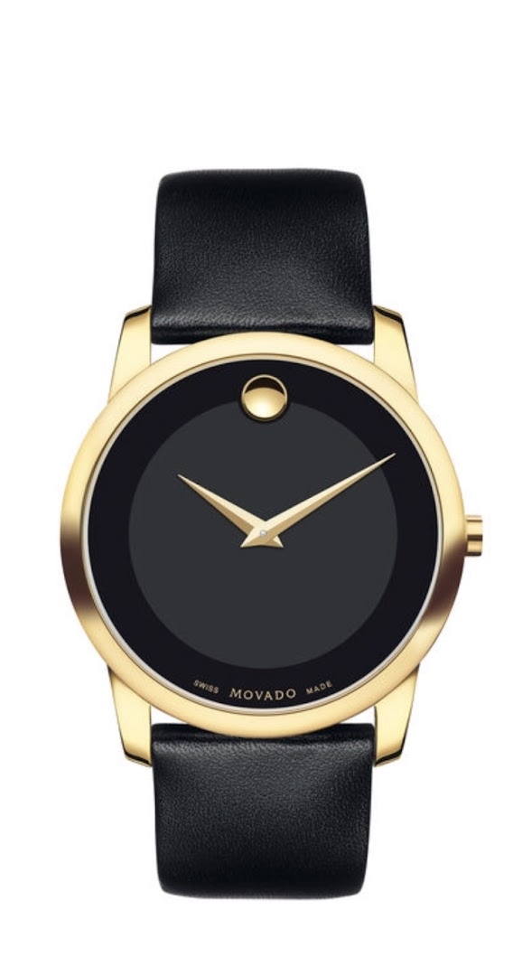 A close-up shot of a gold Movado watch with a black dial and black leather strap.