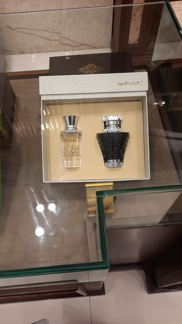 A display box featuring two elegant perfume bottles from Almajed For Oud.