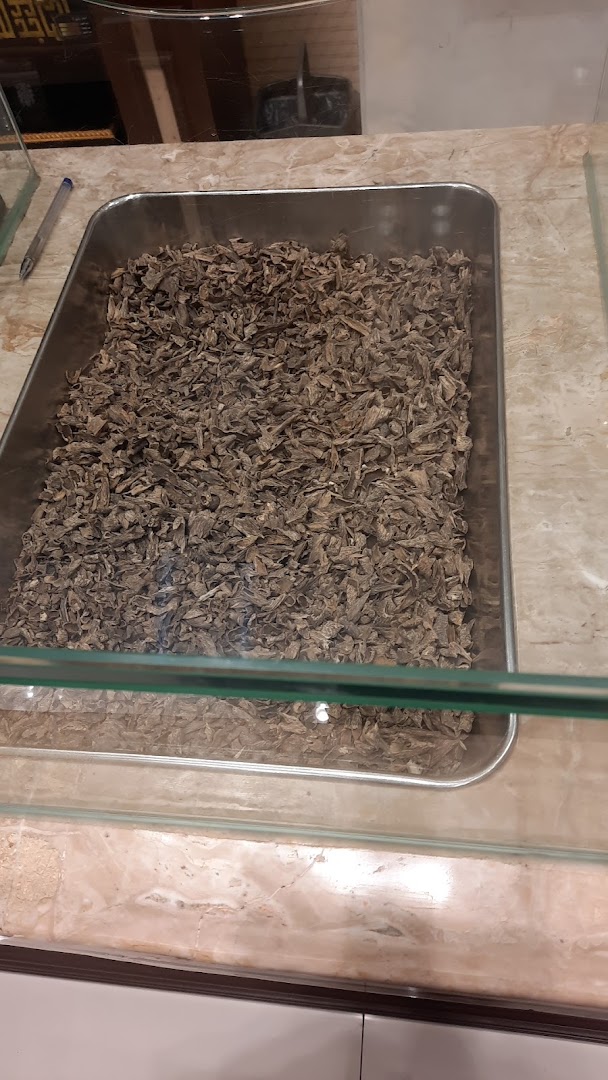 A display of dried oud wood chips in a metal tray at Almajed For Oud.