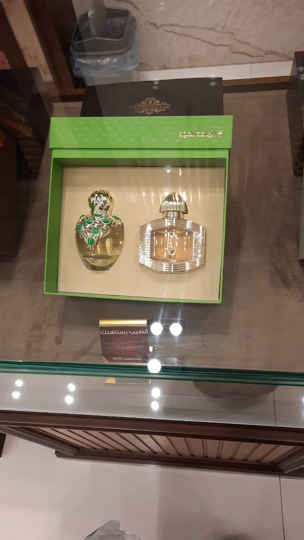 A display case showcasing two elegant perfume bottles, one adorned with green stones.