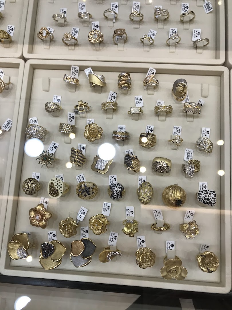 A display case filled with various gold rings, showcasing intricate designs and precious stones.