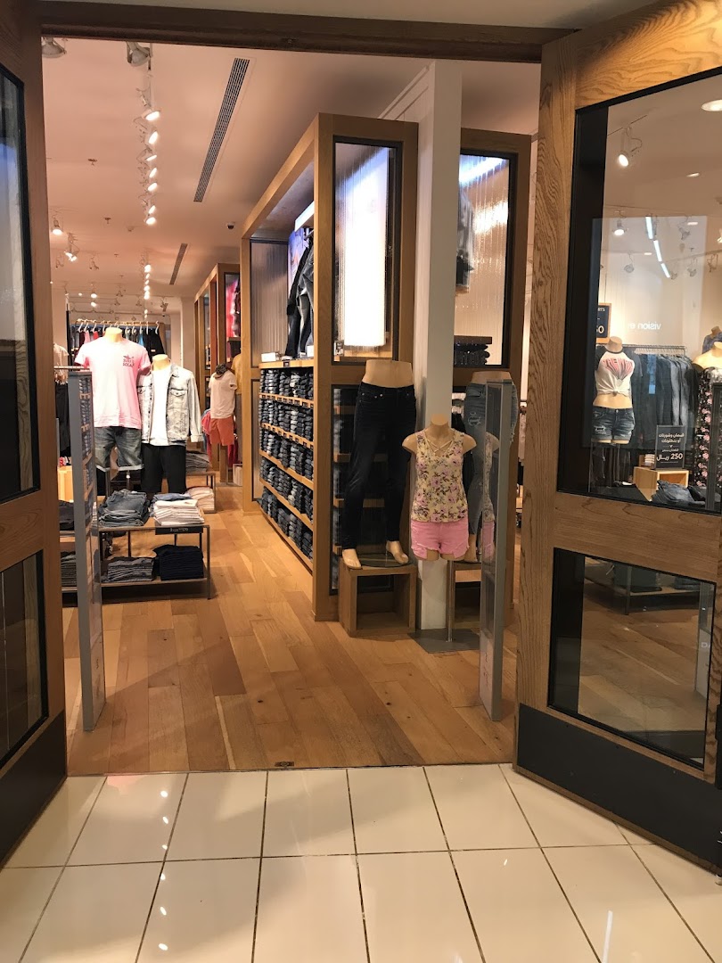 Interior view of an American Eagle store showcasing denim and apparel on mannequins and shelves.