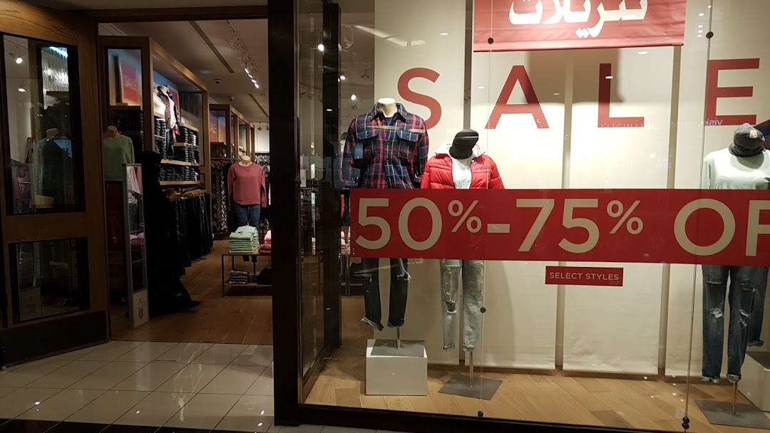 American Eagle store window display featuring mannequins and a large sale sign.