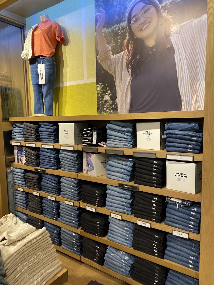 American Eagle store display featuring a mannequin and shelves stocked with folded jeans.