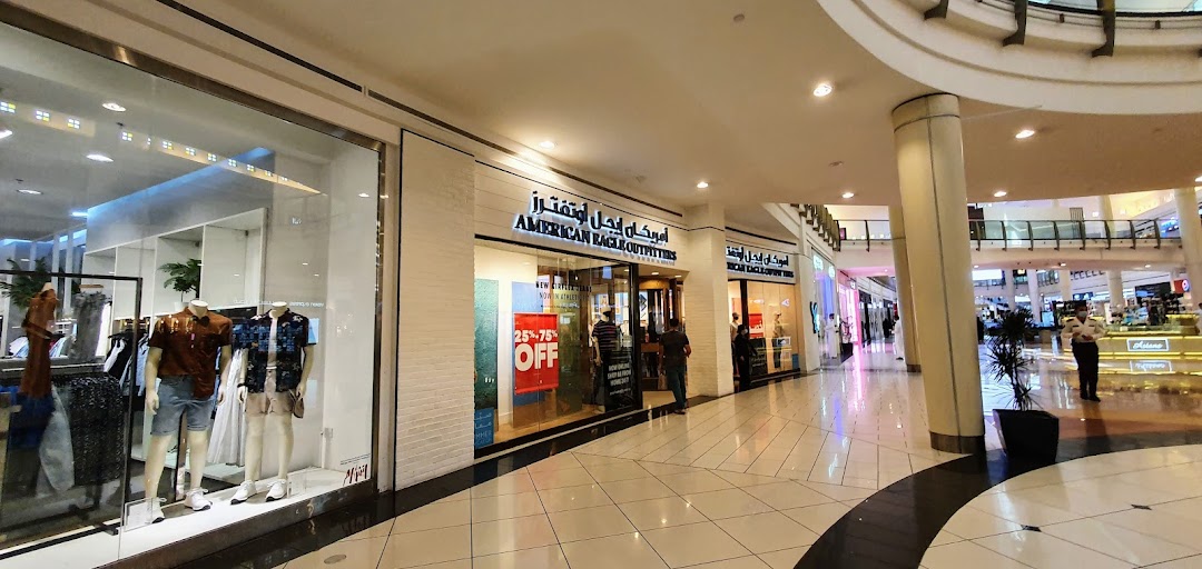 The exterior of an American Eagle Outfitters store in a shopping mall, featuring mannequins and a sale sign.