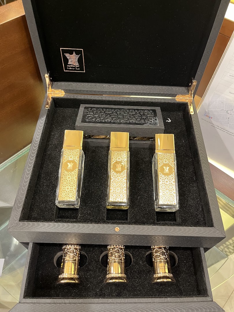 A luxurious gift set featuring three ornate perfume bottles and decorative caps in a presentation box.