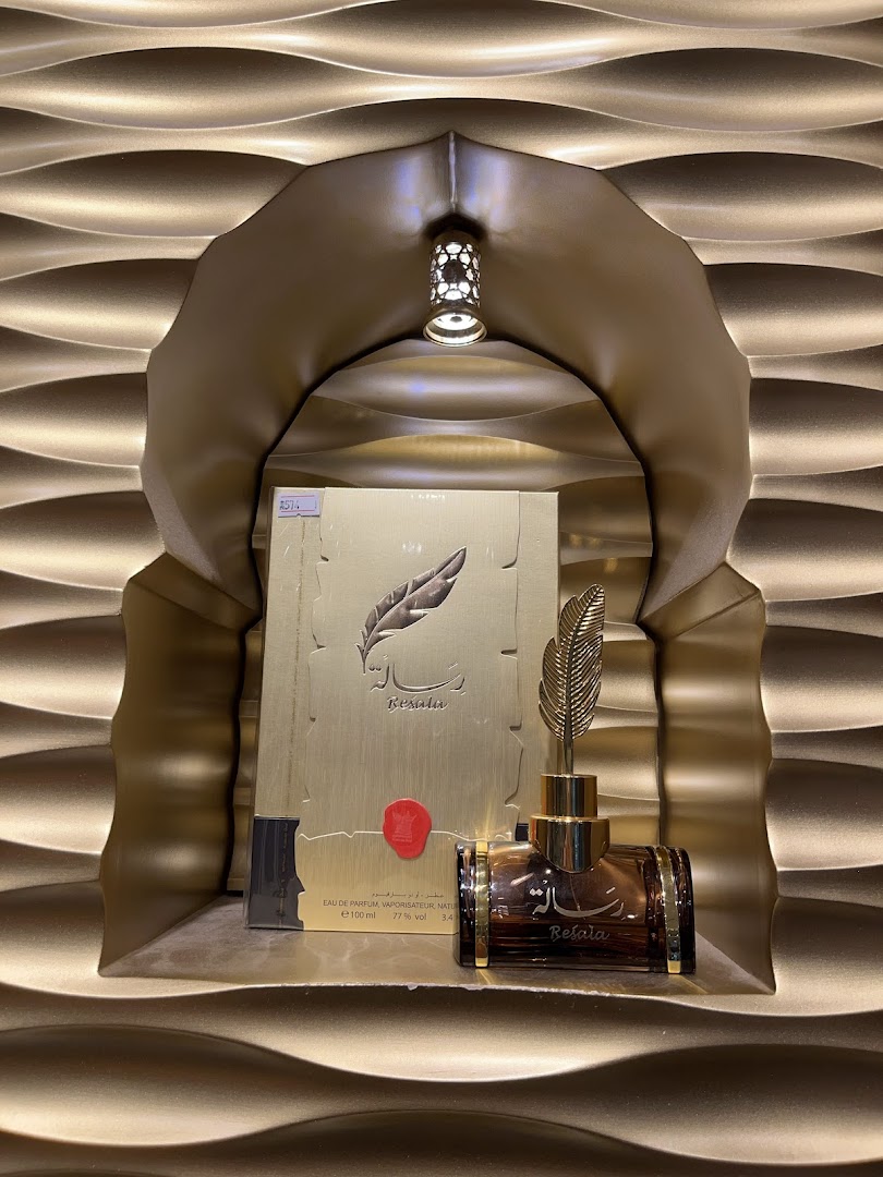 A bottle of 'Resala' perfume from Arabian Oud displayed in a golden, wave-patterned niche.