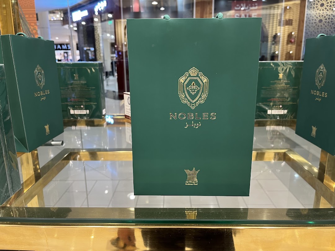 Green shopping bags with gold logos and text from Arabian Oud.