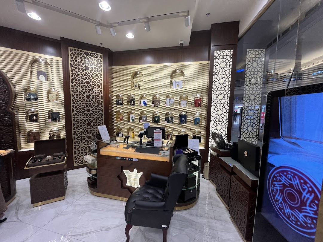 Interior view of a luxurious Arabian Oud perfume shop with display shelves and a counter.