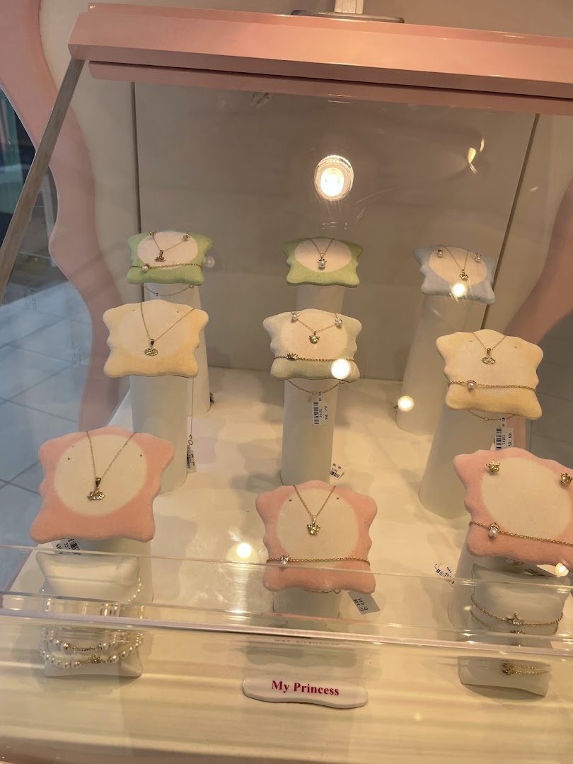 A display case showcasing delicate gold necklaces and bracelets for children.