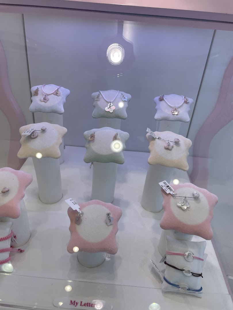 A display case showcasing delicate jewelry, including necklaces and earrings, for children.