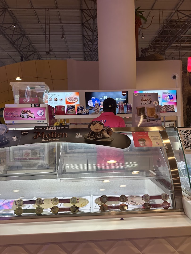 A Baskin Robbins counter with ice cream tubs and promotional displays.