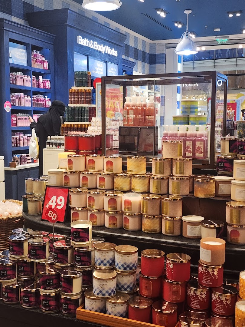 A wide display of Bath & Body Works candles and lotions, with a sale sign.