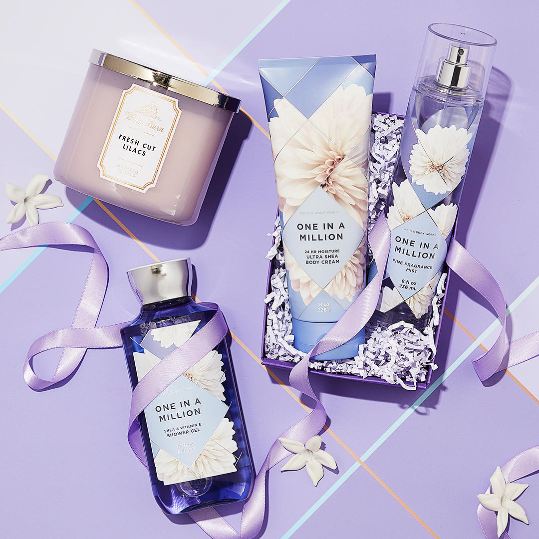A collection of Bath & Body Works products including a candle, body cream, shower gel, and fragrance mist.