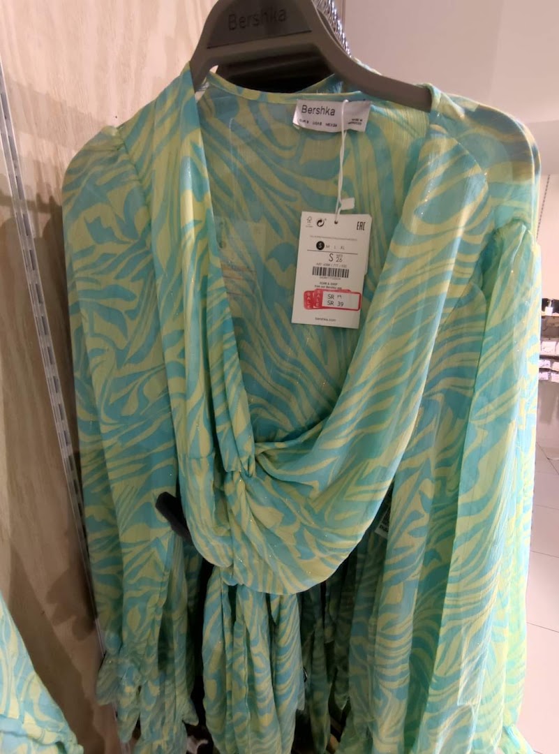 A light blue and yellow patterned dress with a price tag hanging from the neckline.