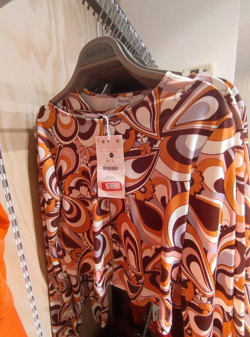 A close-up of a colorful, retro-patterned long-sleeved shirt from Bershka.