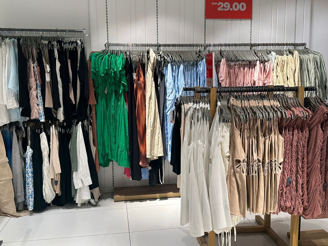 A wide selection of women's clothing displayed on racks, featuring dresses and tops in various colors.