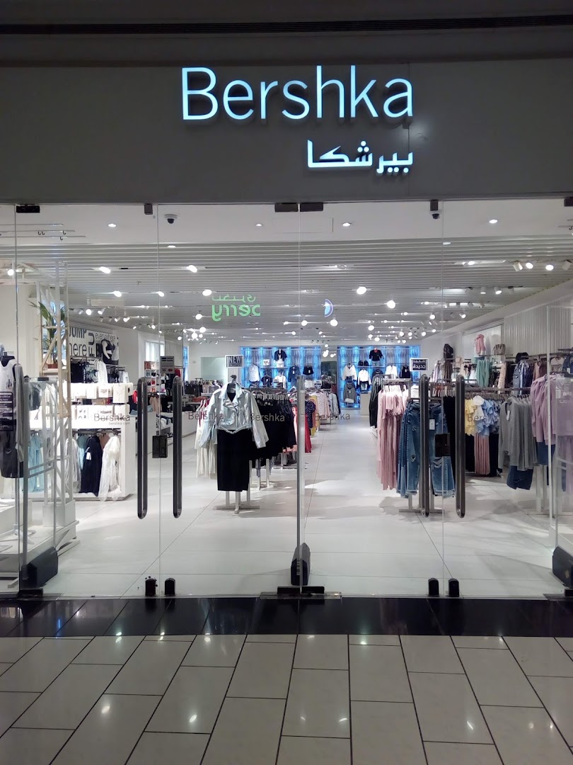 The entrance to a Bershka clothing store, showcasing stylish apparel displayed on racks and mannequins.