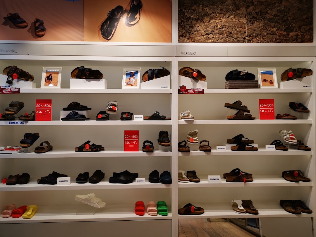 A well-organized display of Birkenstock sandals and shoes on multiple shelves.