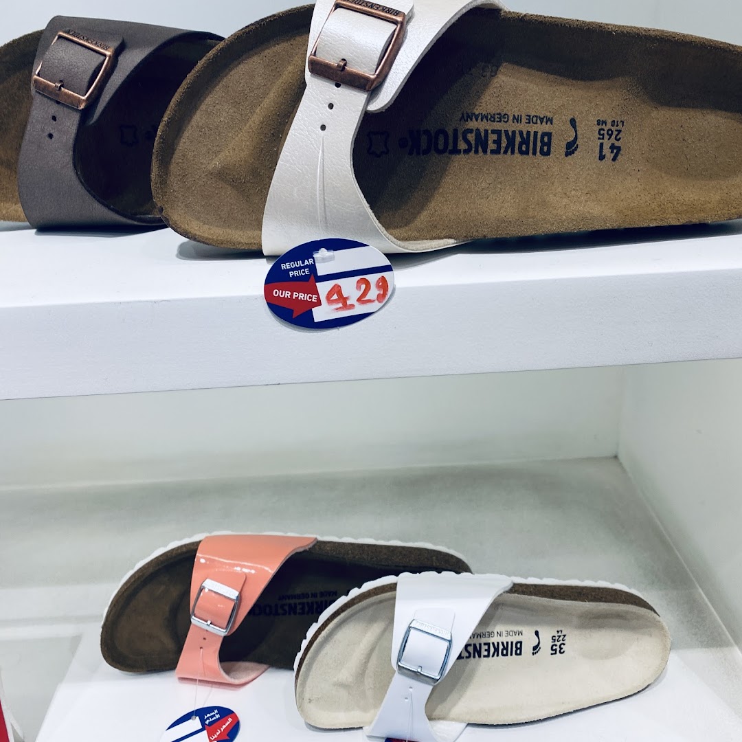 Close-up of Birkenstock sandals on display, showing different colors and a price tag.