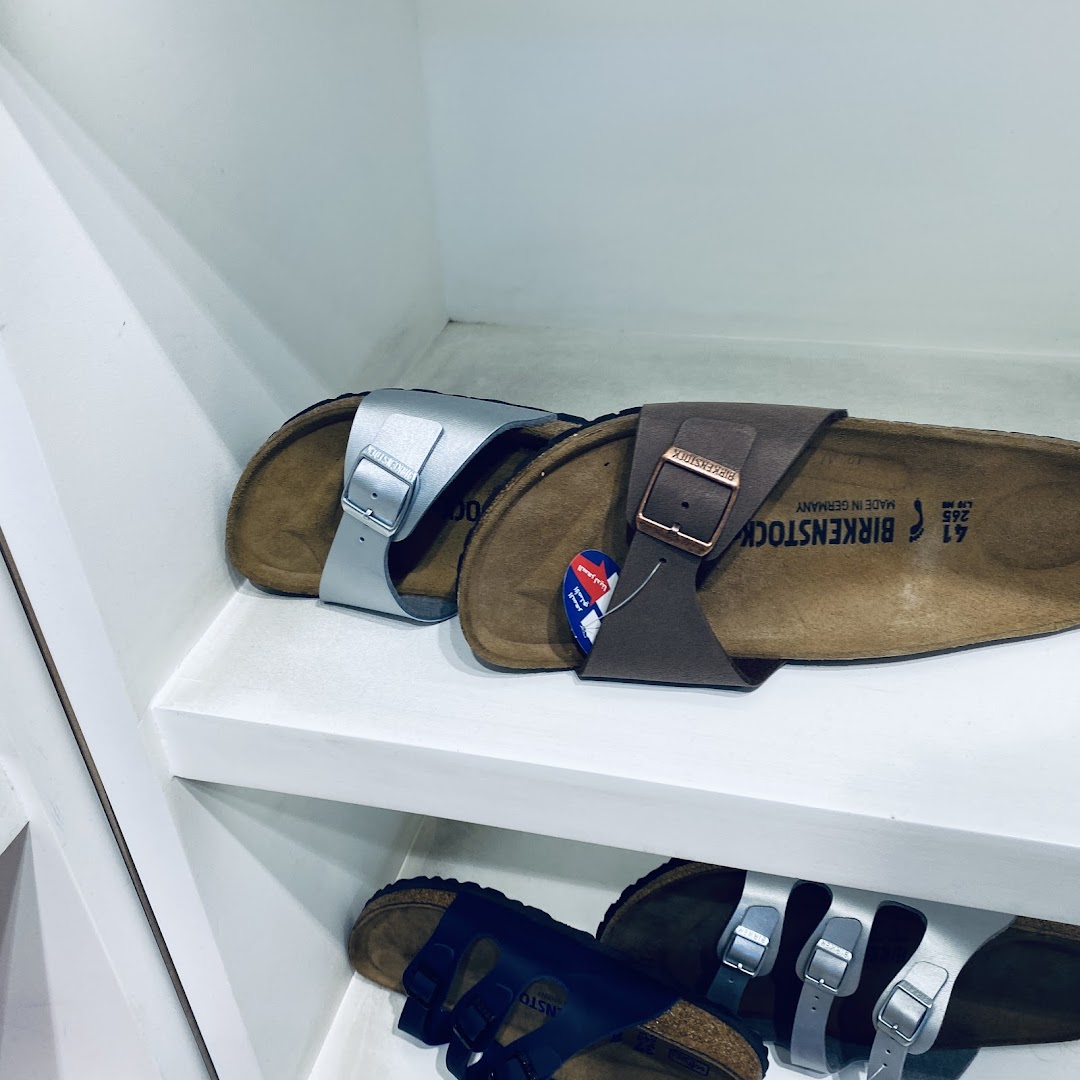A close-up shot of several Birkenstock sandals displayed on white shelves.