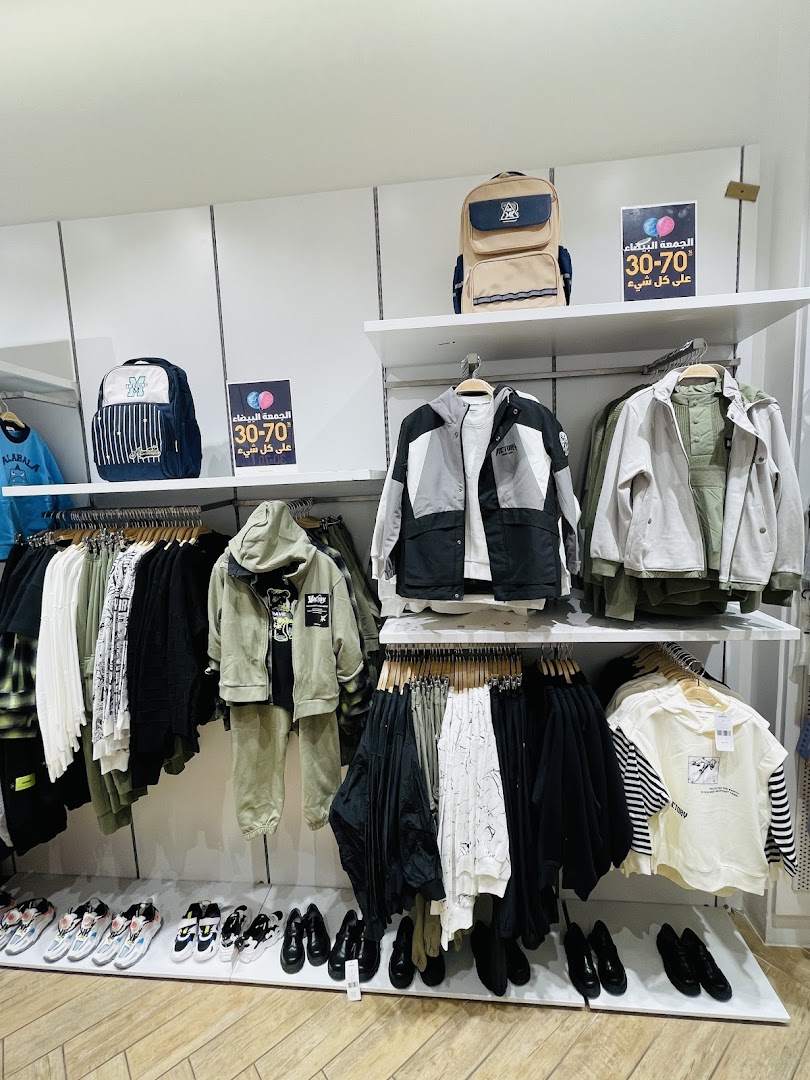 A retail shop displaying a variety of clothing, backpacks, and shoes, with sale signs.