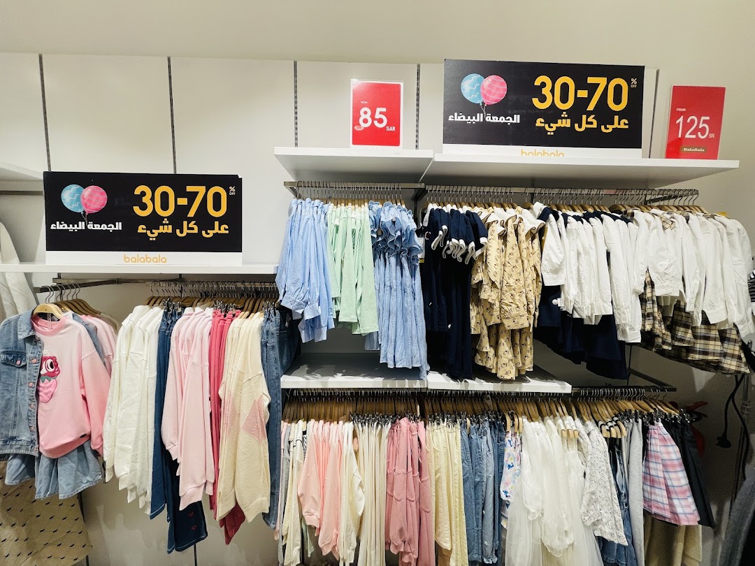 A clothing store display featuring racks of colorful children's clothes with sale signs.