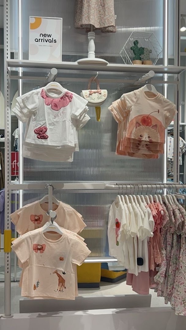 A display of cute children's clothing featuring animal prints and pastel colors.